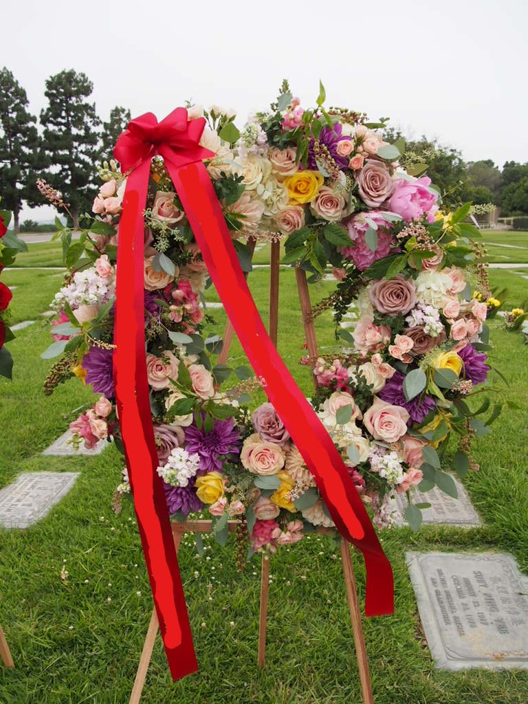 Farewell Farewell - Round funeral wreath with seasonal flowers on an easal.