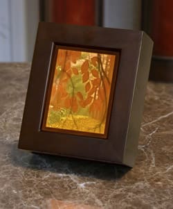 Colored Secret Path Lithophane Lamp Colored Secret Path Lithophane Lamp - This exquisite colorful Secret Path Lithophane Lamp is hand carved in fine transparent earthenware which glows when lit and is set in a sleek Cherry Wood Shadow Box. A unique new addition to our Memory Lamps. 6 x 5 1/4" includes a 15-watt bulb. Deluxe version includes a wreath of fresh flowers to compliment the lamp