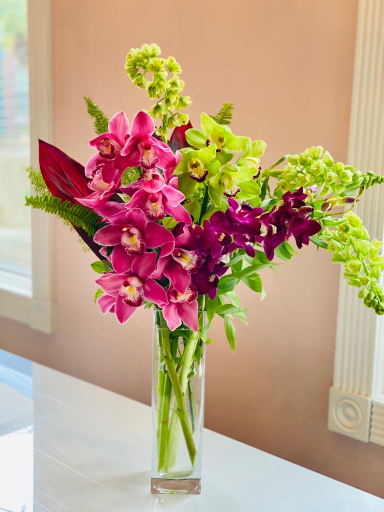Verdant Sprite  - A lush and playful creation that can brighten anyone’s day. This stunning arrangement features a collection of orchids, which may include cymbidium and dendrobium orchids in variety of colors.    Please note that Aquafuzion prides itself on its green thumb, and there may be substitutions depending on seasonal availability. 