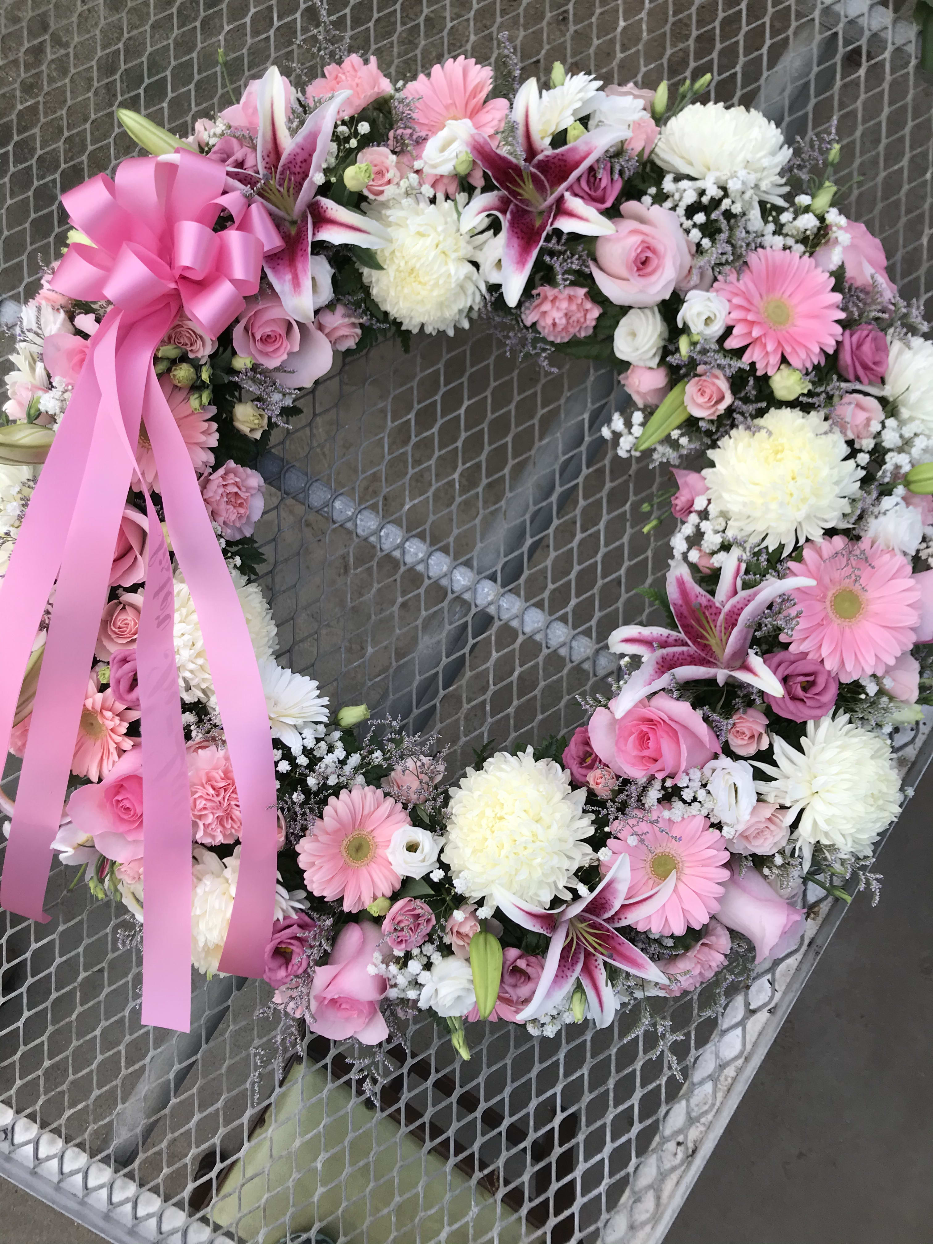 Elegance Wreath - Open wreath with shades of pinks. Roses, lilies, mums and daisies.
