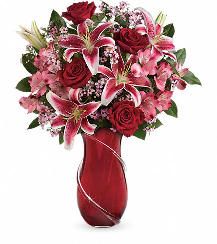 Teleflora's Wrapped With Passion Bouquet - by Collene's Crafts-N-Flowers - The ultimate in Valentine's Day luxury! Inspired by Italian art glass this exquisitely crafted hand-blown glass vase is a keepsake she'll treasure forever. Its graceful shape and sparkling hand-applied glass ribbon are the perfect complement to this dramatic bouquet of romantic long stemmed red roses and fragrant pink stargazer lilies. Long stemmed red roses pink stargazer lilies and dark pink alstroemeria are artistically arranged with lavender waxflower and lemon leaf. Delivered in a Wrapped With Passion vase.Approximately 18 1/2&quot; W x 21 3/4&quot; H Orientation: One-Sided As Shown : T16V200ADeluxe : T16V200BPremium : T16V200C