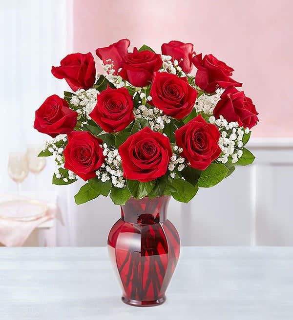 Blooming Love -  Sometimes flowers speak louder than words…and our elegant red roses speak volumes! Beautifully hand-arranged with lush greenery inside our exclusive ruby red vase, each radiant bloom will help you express your love in the most romantic way possible.