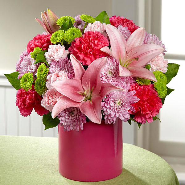 The FTD Sweetness & Light Bouquet The FTD Sweetness & Light Bouquet - Embrace the sweetness of life with this gorgeous array of blushing blooms set to celebrate any of your special occasions with style and grace. Hot pink roses are paired with pink Asiatic Lilies surrounded by hot pink carnations lavender chrysanthemums green button poms pink mini carnations and lush greens presented in a hot pink cylinder ceramic vase to create a colorful and lively floral arrangement. A beautiful birthday anniversary or thank you gift! GOOD bouquet includes 14 stems. Approx. 11"H x 11"W. BETTER bouquet includes 16 stems. Approx. 12"H x 12"W. BEST bouquet includes 21 stems. Approx. 13"H x 13"W.