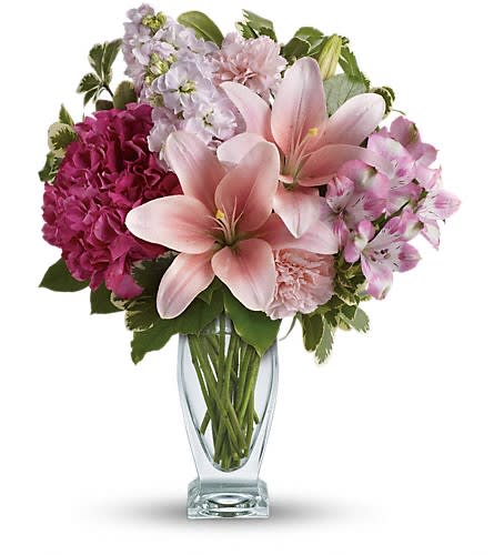 Teleflora's Blush Of Love Bouquet Teleflora's Blush Of Love Bouquet - Celebrate your love with this beautifully blushing bouquet! Luxurious lilies delicate hydrangea and fragrant stock delight her senses soothe her soul and tickle her fancy. It's a loving gift she won't soon forget! Includes pink hydrangea asiatic lilies alstroemeria carnations and stock accented with fresh greens. Delivered in a Couture vase.Approximately 14" W x 17" H Orientation: One-Sided As Shown : TEV21-1ADeluxe : TEV21-1BPremium : TEV21-1C