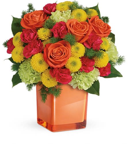 Teleflora's Citrus Smiles Bouquet Teleflora's Citrus Smiles Bouquet - They brighten your days with their friendship and love brighten theirs with these bold and beautiful blooms! Hand-delivered in a stylish glass cube a gift in and of itself - this spirited mix of roses carnations and mums is sure to make them smile! Bold orange roses green carnations dark pink miniature carnations and yellow button spray chrysanthemums are mixed with ming fern and lemon leaf. Delivered in a glass cube.Approximately 11 1/2" W x 11 3/4" H Orientation: One-Sided As Shown : TEV43-3ADeluxe : TEV43-3BPremium : TEV43-3C