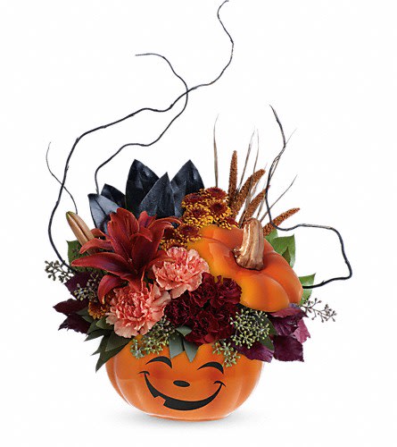 Teleflora's Halloween Magic Bouquet - What a &quot;boo&quot;-tiful way to wish them a Happy Halloween! This spirited mix of lilies carnations mums and fun fall accents is hand-delivered in a delightful ceramic pumpkin the perfect Halloween candy jar! This magical bouquet features rust-colored asiatic lilies orange carnations miniature maroon carnations brown button spray chrysanthemums magnolia leaves burgundy copper beech seeded eucalyptus lemon leaf curly willow and dried brown china millet. Delivered in a Halloween Magic Pumpkin container. Approximately 14 3/4&quot; W x 19 3/4&quot; H Orientation: One-Sided As Shown : T15H100ADeluxe : T15H100BPremium : T15H100C