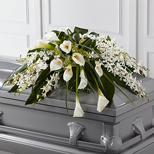 The FTD Angel Wings Casket Spray -  The FTD® Angel Wings™ Casket Spray is an exceptionally gorgeous way to bring peace and beauty to their final farewell service. White Dendrobium orchids, white calla lilies, green hydrangea and a variety of lush greens are artfully arranged to perfectly adorn the top of their casket, offering the colors and ambience of grace and serenity.