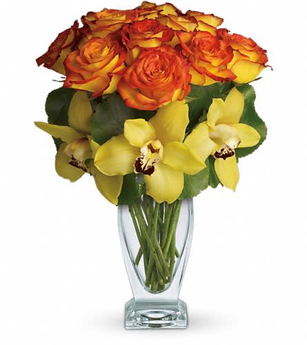 Teleflora's Aloha Sunset - Aloha is a celebration of joy gratitude and being in the present. Lovely orchids celebrate the spirit of aloha especially when mixed with gorgeous roses evocative of a Hawaiian sunset. This stunning arrangement has it all. Beautiful yellow cymbidium orchids brilliant bi-color roses and tropical leaves all hand-delivered in a striking Couture Vase. It's definitely a departure from the everyday!Approximately 11 1/2&quot; W x 15&quot; H Orientation: All-Around As Shown : T73-1ADeluxe : T73-1BPremium : T73-1C