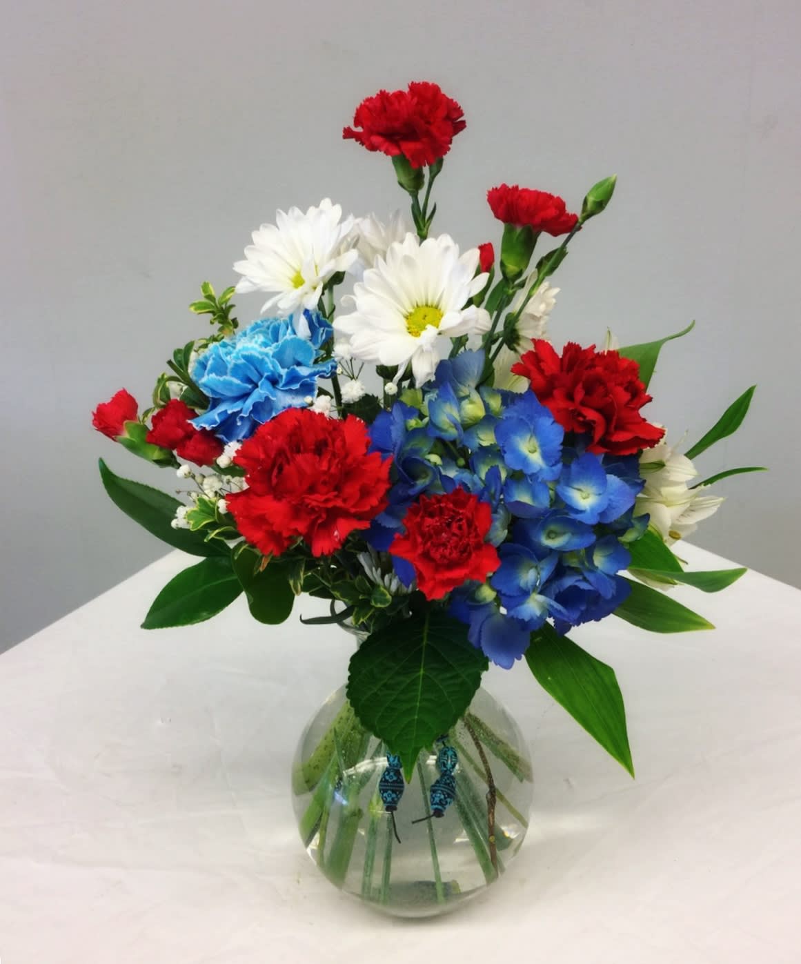 Bold in Blue - This festive red, white and blue bouquet is perfect for the season. Limited supplies. Don’t miss out! 