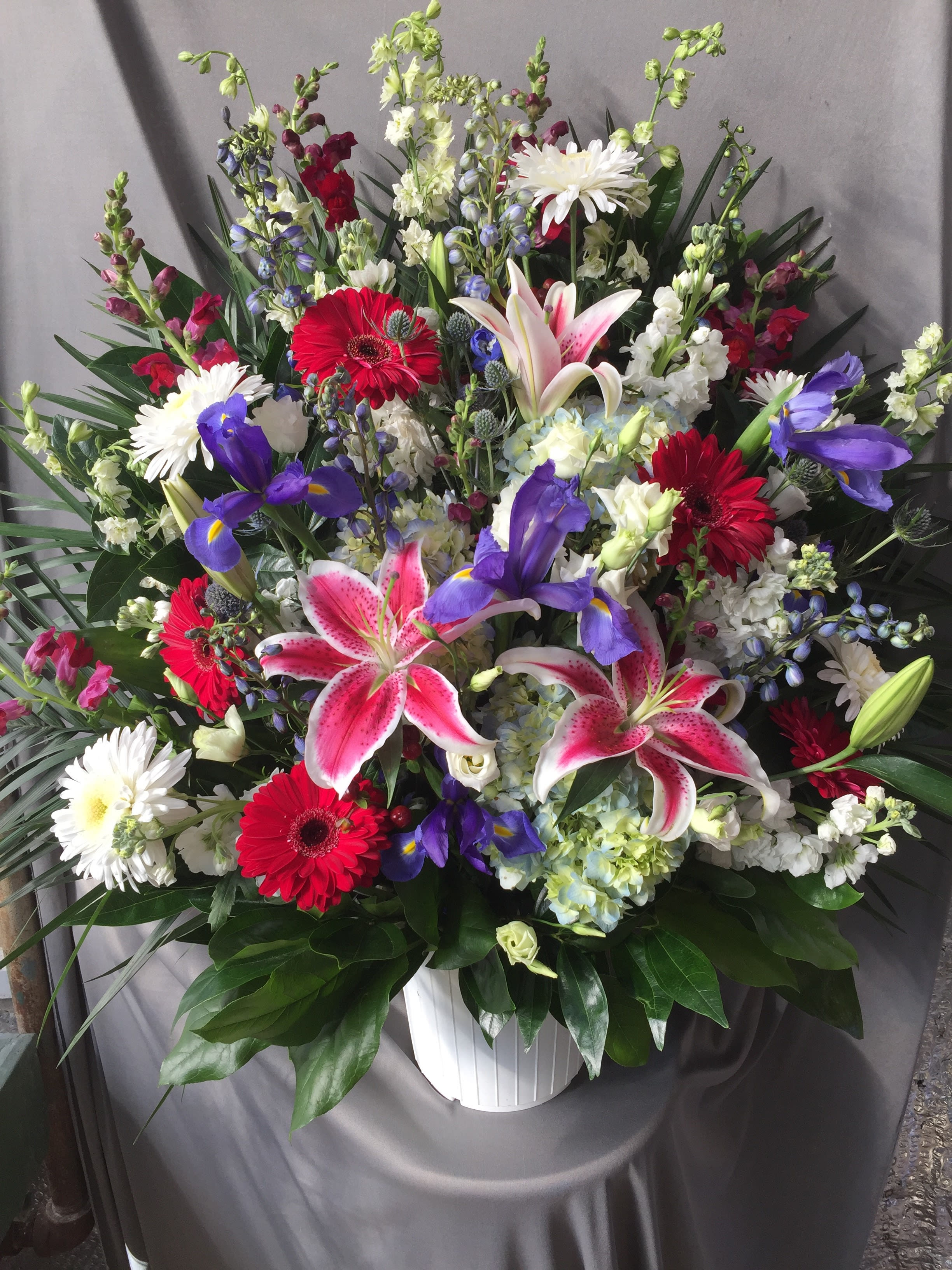 Jewel Toned Funeral Container - A seasonal mixture of flowers in shades of white, pinks, and blues.  