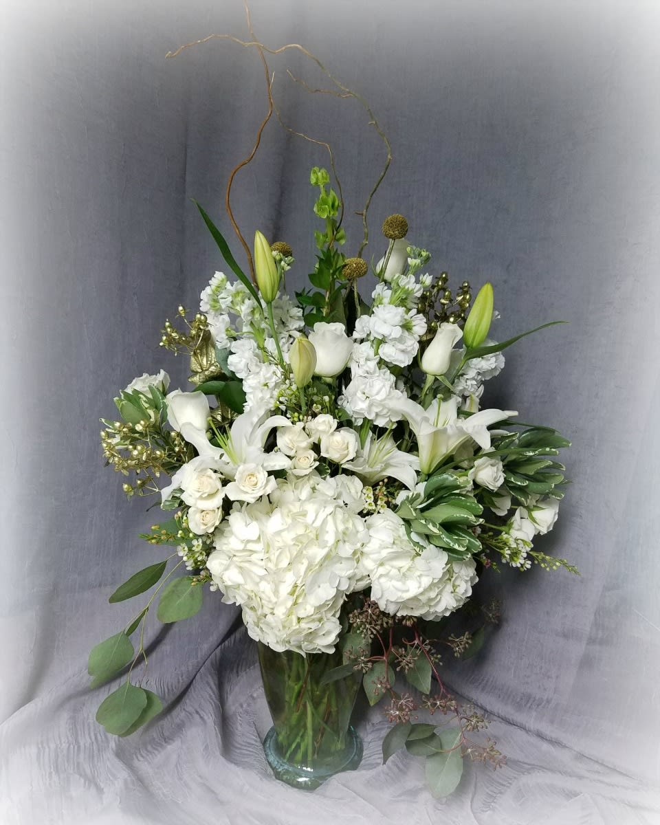 Romantic Garden - Walk through the lovely garden hand in hand with your special someone and this large, beautiful bouquet! Featuring all white flowers with gold accents, this is as classy as they come. Wow them with this array of hydrangeas, 12 white roses, lilies, stock and much much more! Don't let the photo fool you, this is a very large bouquet and is sure to impress!!