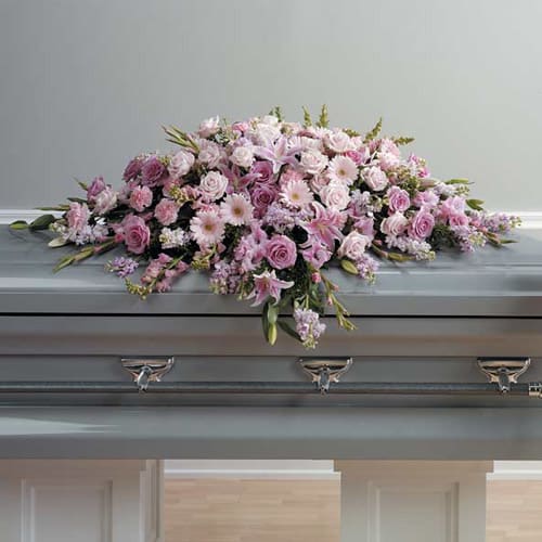 Pink Casket Spray - Casket spray contains light pink gerbera daisies, pink roses, pink stock, pink snapdragons, pink carnations, lavender stock,  lilies, salal, and myrtle.