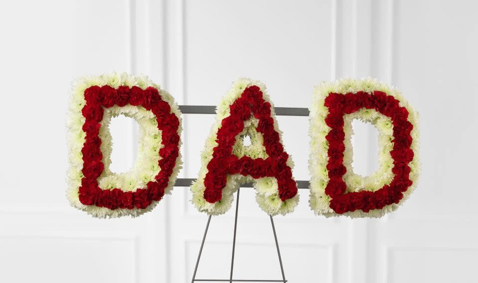 Remembering Dad Arrangmenent - emembering Dad Arrangement is the perfect way to commemorate your father at his final farewell service. White chrysanthemums and red mini carnations are beautifully arranged to form the word, &quot;&quot;Dad,&quot;&quot; to create a wonderful way to express the love you have for the man that gave you so much throughout the years. Displayed on a wire easel. 