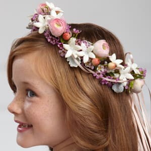  The FTD® Lila Rose™ Headpiece  -  The FTD® Lila Rose™ Headpiece will make any flower girl glow. Pink ranunculus, white stephanotis blooms, pink waxflower, peach hypericum berries and dusty miller stems are arranged in the perfect circle and accented with peach satin ribbon to crown her head on the wedding day, giving your flower girl a sweet look for her big moment.    SKU#: W23-4676 