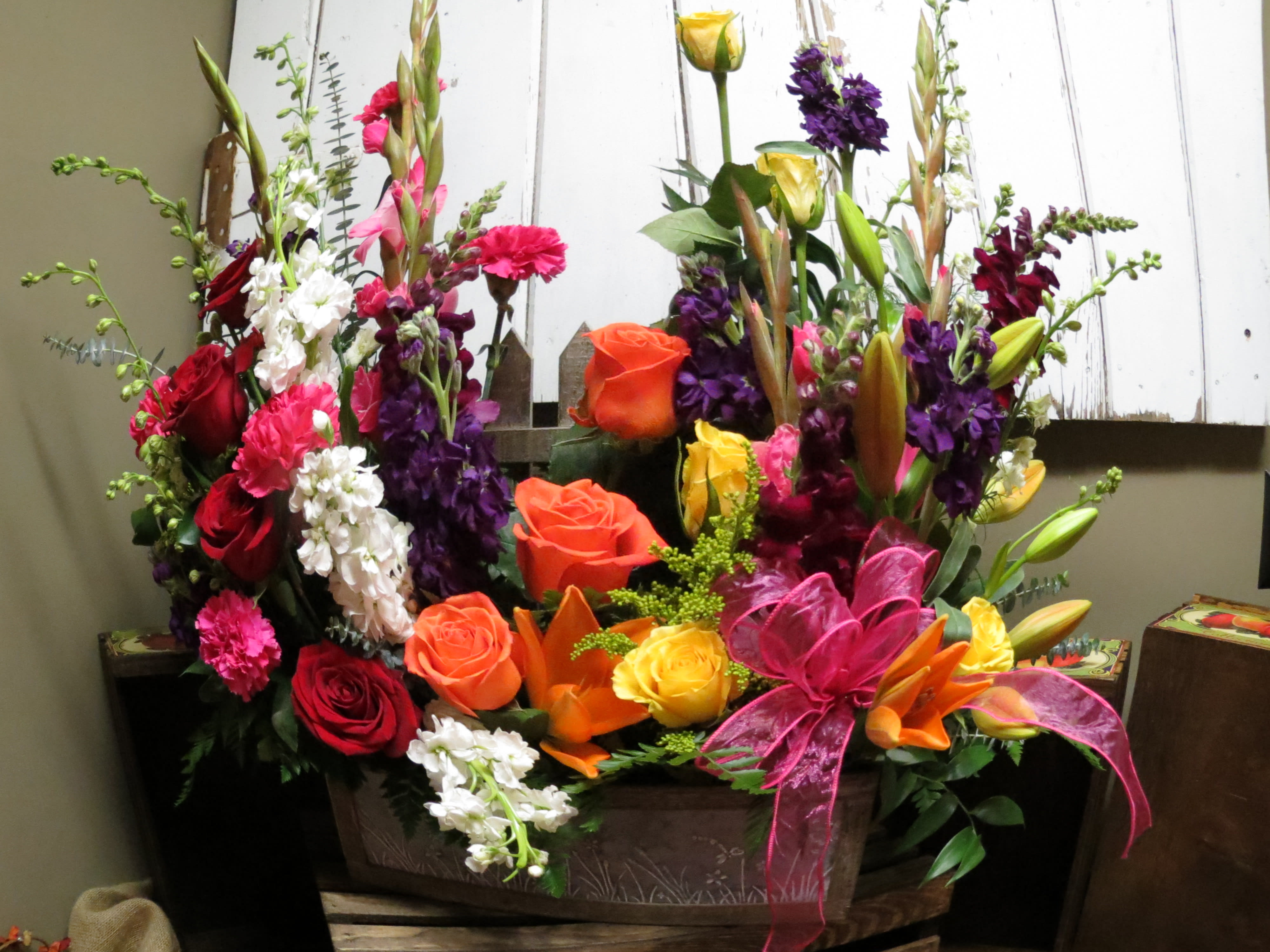 Rest in Peace Bouquet Custom Design by Cold Spring Floral Rest in Peace Bouquet Custom Design by Cold Spring Floral - A Beautiful Mix of Fresh Flowers, Just like in a Garden Setting. Contains Orange, Yellow and Red Roses, Yellow Asiatic Lilies, Purple and White Stock, Pink Carnations, Pink Gladiolas, Burgundy Snapdragons, Mixed Garden Greens and Solidago. Flowers and Container subject to availability.