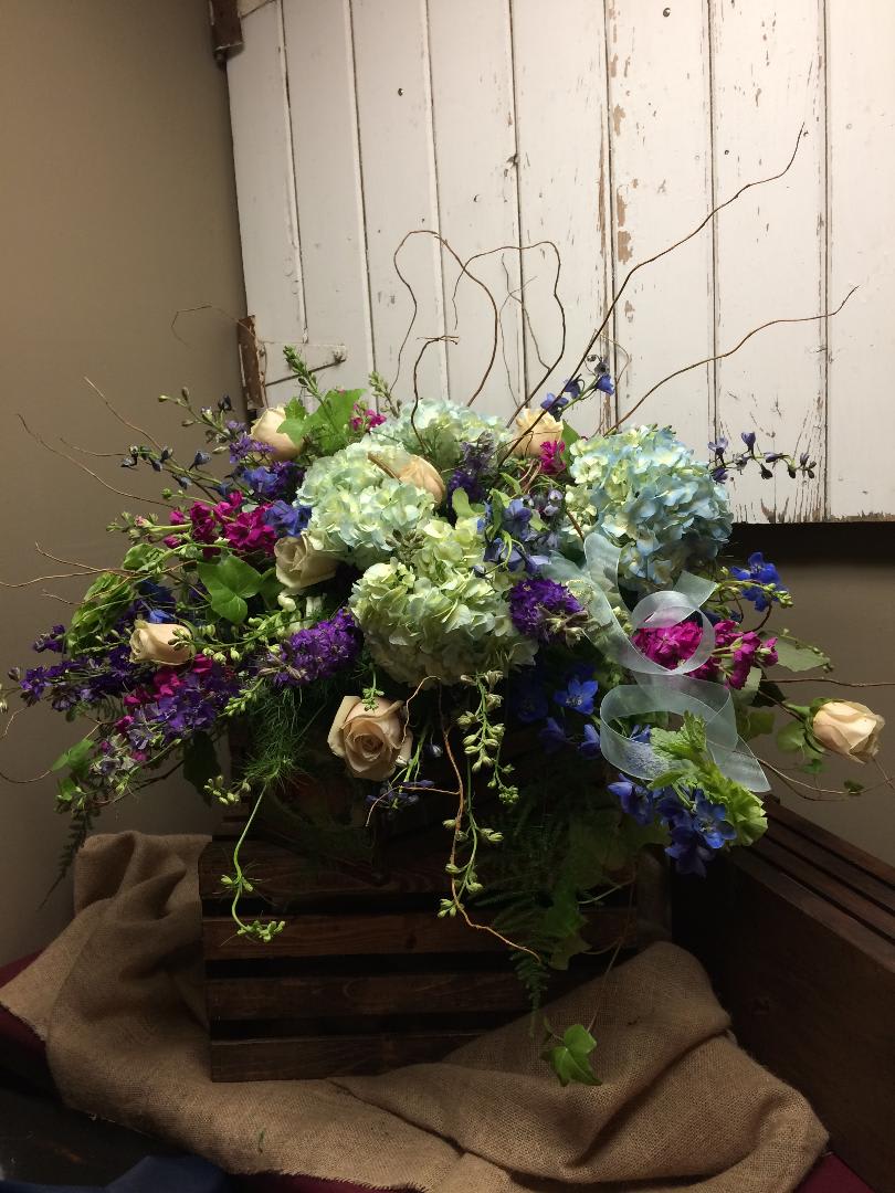 Garden Stroll Custom Design by Cold Spring Floral Garden Stroll Custom Design by Cold Spring Floral - Garden Stroll will add Light and Beauty with the Blue Hydrangea, Purple Larkspur, Fuchsia Stock, Green Roses, Fresh Ivy and Bells of Ireland. Mixed greenery, and Curly Willow add the finishing touches to this bouquet. Exact flowers and container may vary due to availability and are subject to substitutions.