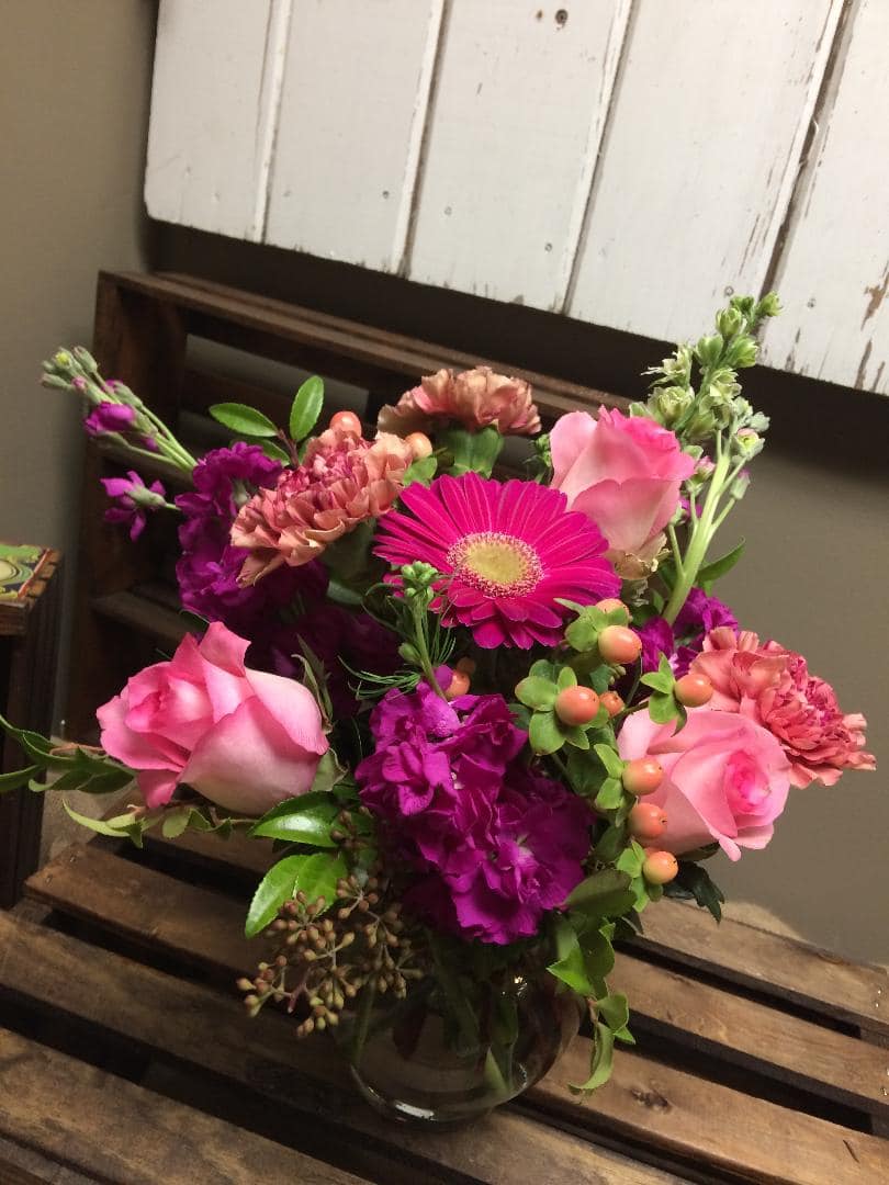 Pink Perfection - This arrangement includes pink roses, purple stock, hot pink gerbera daisy, peach hypericum berry, pink carnations and lush greens.   