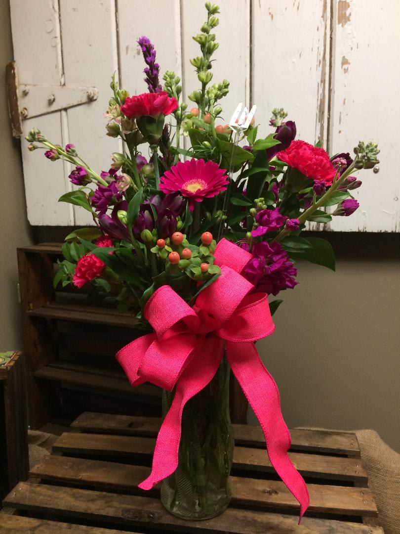 Pretty in Pink - This beautiful vase arrangement includes hot pink gerbera daisy, hot pink carnations, purple Alstroemeria, purple stock, peach hypericum berry, pink larkspur and lush greens. 