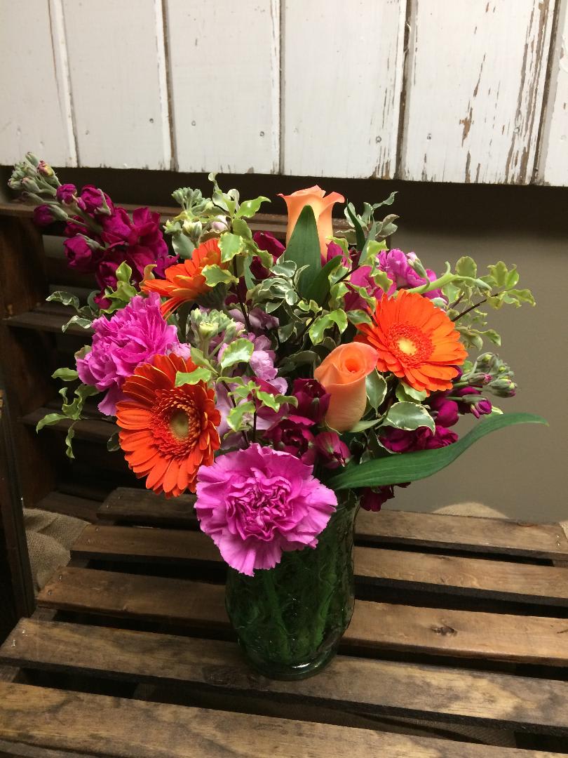 Starburst  - This arrangement includes peach roses, orange gerbera daisies, fuchsia carnations, red Alstroemeria, pink and purple stock, and lush greens.