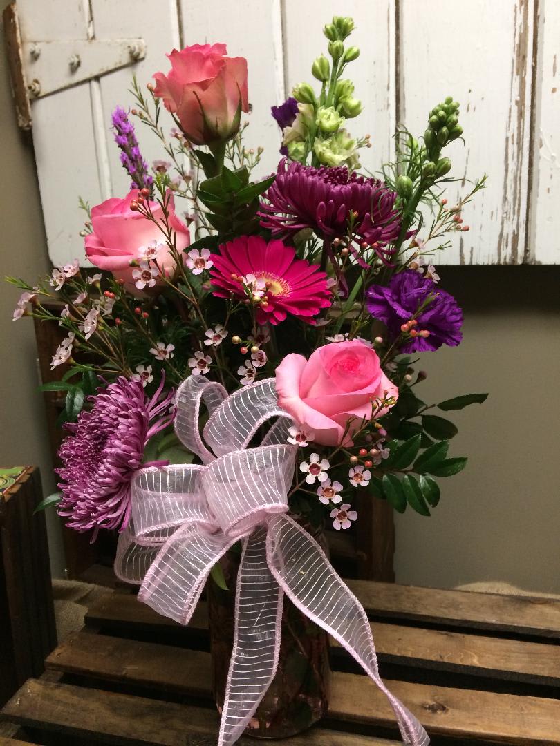 Meadow Fresh - This vase includes pink roses, hot pink gerbera daisy, plum Fuji mum, purple liatris, purple carnations, white larkspur pink wax flowers and lush greens. 