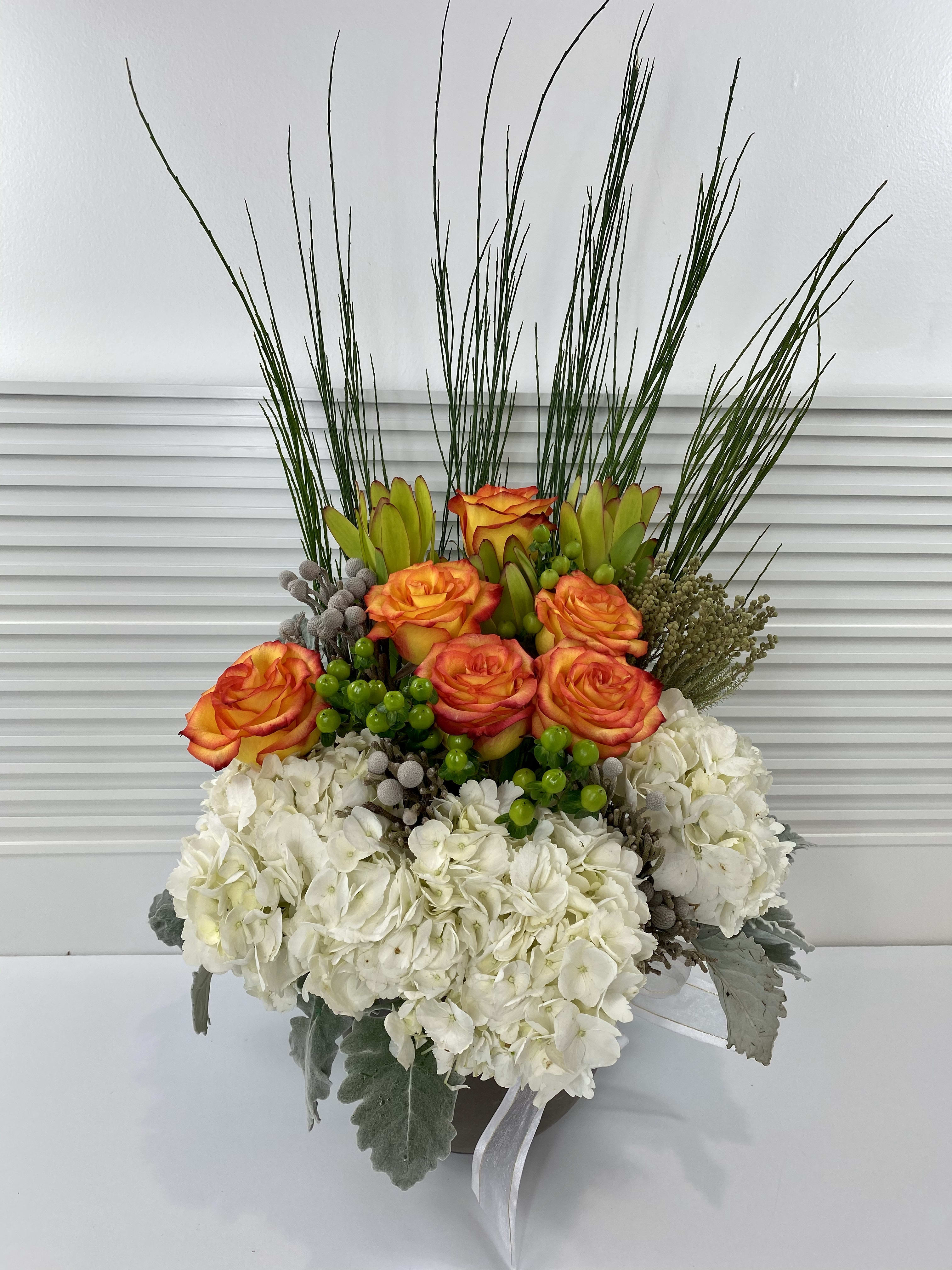 Modern High Magic - Modern high magic roses, hydrangeas and rich mix of greenery in a circular pottery vase.