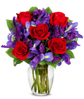 Ruby Rose Bouquet - Rubies are red...and so are the roses in this romantic arrangement all set to take someone's breath away. Purple statice, blue iris and a lovely clear garden vase also contribute effortlessly to a look of total beauty. Small Measures 16&quot;H X 10&quot;L. Medium Measures 17&quot;H X 11&quot;L. Large measures 18&quot;H X 12&quot;L.