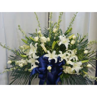 Funeral Basket - White Flowers - This beautiful floral tribute is the perfect way to express sorrow for that close family member or dear friend. It is a beautiful combination of larkspur, lilies, and roses professionally designed by Paradise Flower Market.