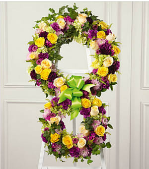 The FTD® Eternity™ Standing Easel - The soul's passage into the hereafter is celebrated with this inspiring floral tribute handcrafted by a local FTD artisan florist to reflect the symbol of &quot;infinity&quot;. The two conjoined wreaths are constructed of yellow roses, fuchsia and purple carnations, fuchsia dianthus, lavender pompons and golden solidago accented with lush greens and trimmed with coordinating ribbon. It is a powerful and lovely statement of faith that is sure to console and comfort all who share your loss.  Your purchase includes a complimentary personalized gift message.