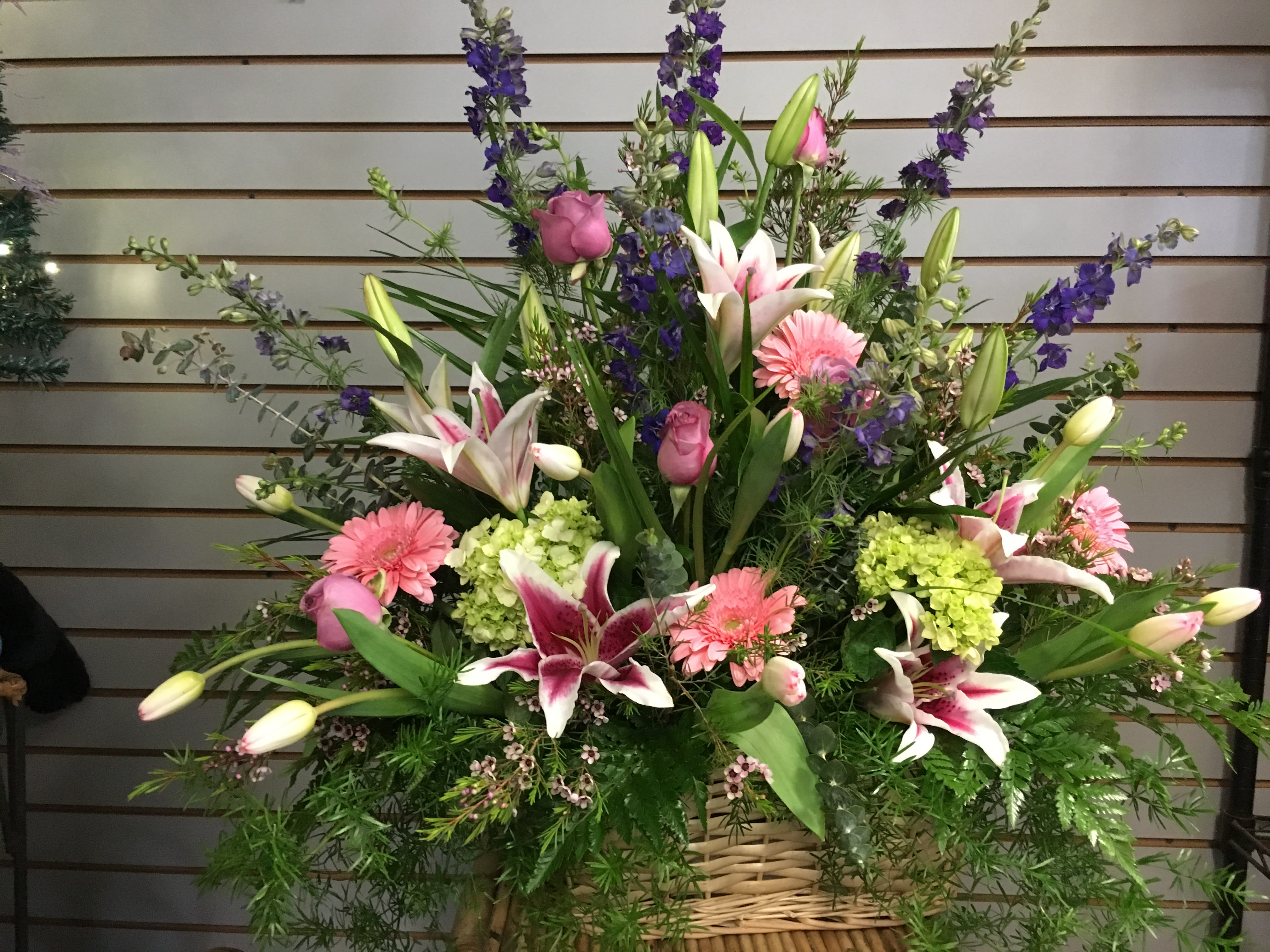 Remembrance in Beauty Remembrance in Beauty - This beautiful wicker basket, "Remembrance in Beauty" makes a great companion peace for the family (banners may be added) or a wonderful sentiment from friends. With a premium assortment of flowers, including stargazers lillies, roses, larkspur, carnations and hydrangeas, this arrangement makes a bold and brilliant statement. Colors and flowers may vary dependent on your choices and availability.