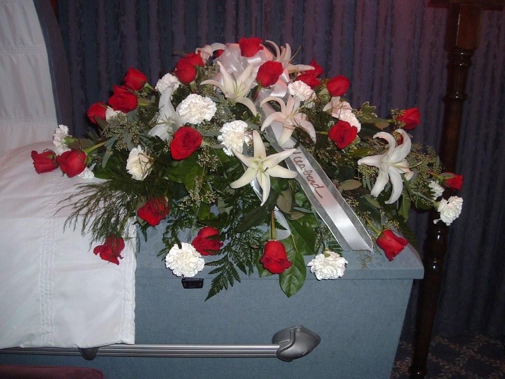Dear Love Casket Cover - Red roses and white lilies, with silver dollar eucalyptus and greens, reflect reflect love for the departed in this traditional casket cover.