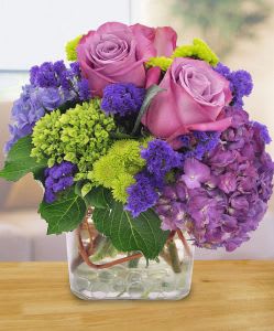 Purple Happiness Purple Happiness - Celebrate someone special in style with this luxurious arrangement featuring lavender roses, purple and green hydrangeas and purple statice, along with green pompons and curly willow tips. This elegant design is bold and fit for royalty.