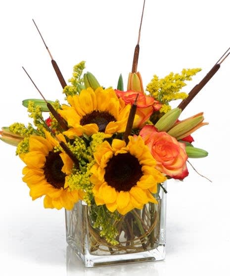The Colors of Autumn The Colors of Autumn - The colors of autumn richly displayed with sunflowers, roses and lily's in a clear vase.