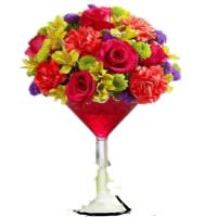 Our Potent Sangria Our Potent Sangria - Spice things up with our fresh floral Sangria cocktail! A vibrant mix of roses, carnations and more are hand-gathered, then served up inside a classic martini glass to start every celebration with a smile! This hand-crafted arrangement of hot pink roses, orange carnations, hot pink mini carnations, yellow alstroemeria, yellow daisy poms, green button poms, purple statice and variegated pittosporum. Flowers may vary dependent on availability.