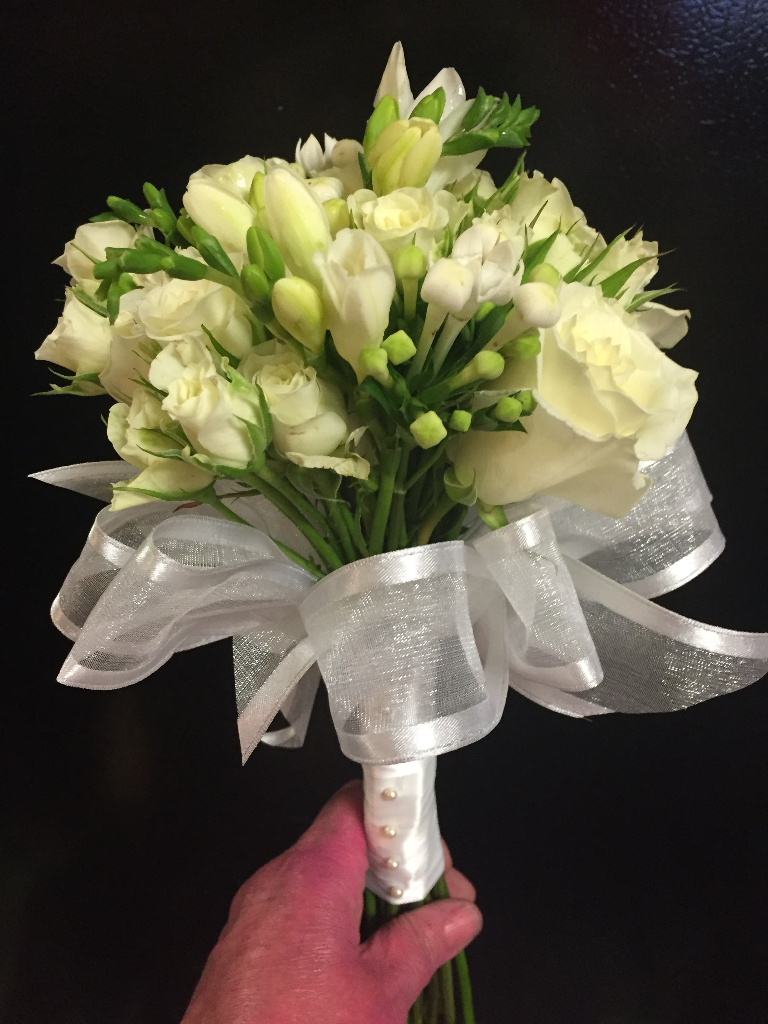 Bride's Bouquet Bride's Bouquet - All white hand tied bouquet with satin wrapped handle. Roses, spray roses, freesia etc.