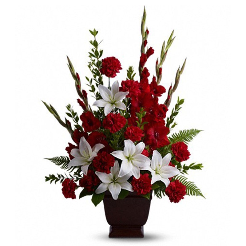 Teleflora's Tender Tribute Teleflora's Tender Tribute - Vivid and touching, vibrant reds and serene whites blend in honor and celebration of a life filled with love, light and grace. Beautiful fresh flowers such as red gladioli and carnations with white asiatic lilies set amidst myrtle, sword fern, and salal in an exclusive Noble Heritage Urn. Orientation: One-Sided All prices in USD ($) Standard T227-1A