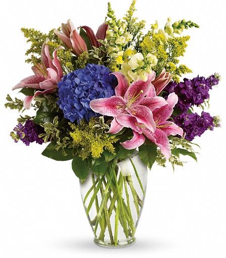 T267-1A Love Everlasting Bouquet T267-1A Love Everlasting Bouquet - Let the family at home know you are thinking of them with this lovely bouquet of pink lilies, blue hydrangea and other floral favorites. It will mean a lot. The stunning bouquet includes blue hydrangea, pink oriental lilies, yellow snapdragons and purple stock, accented with assorted greenery. Delivered in a clear glass Ming urn. Approximately 20" W x 23" H