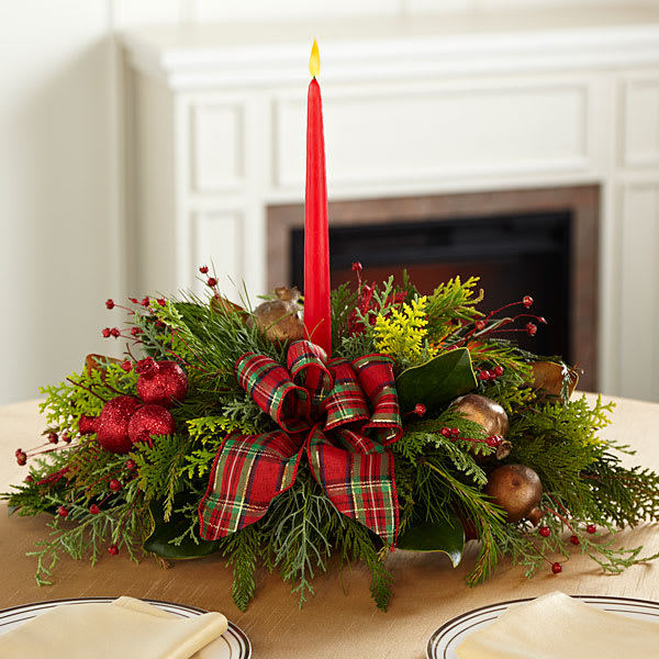 FTD Christmas Callings Centerpiece - The Christmas Callings Holiday Centerpiece offers a classic holiday style that speaks to the heart of the yuletide season. Bringing together bright green cedar at the base accented with golden pomegranates and red holiday berries, as well as, a traditional English red and green plaid bow, this centerpiece is sure to bring light and love to any holiday gathering. Arranged to surround a single 7-inch red tapered candle, this gorgeous centerpiece will be that perfect accent piece for your Christmas table or create a great gift for friends and family across the miles.