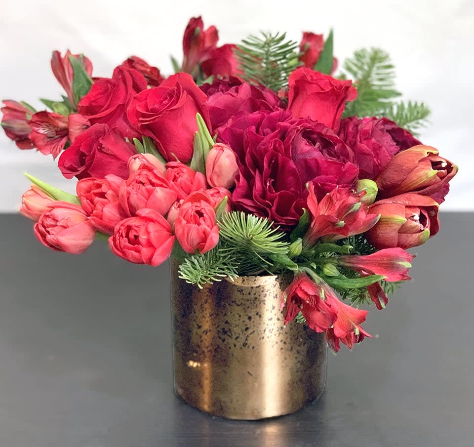 Holiday Magic ADH20-1 - The magic of the holidays in a gorgeous tone on tone floral arrangement of Peonies, Tulips, Roses, and other premium flowers and greens. This is the best of the best. Available in three sizes. Substitution of greens is available. Please note that in special instructions. Approx Size: 10' x 10&quot;