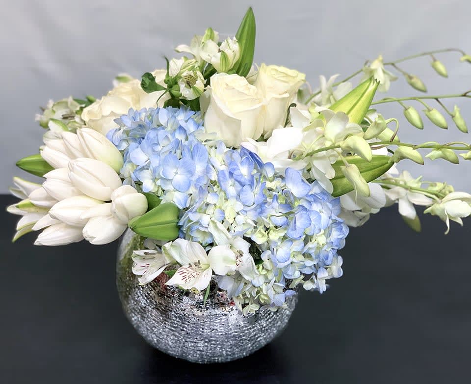 Holiday Lights - Deluxe ADH20-13 - The perfect holiday arrangement to light up a home or office. This gorgeous mix of blue hydrangea, roses, tulips and other premium flowers is available in two sizes. Deluxe version - Approx Size: 12&quot; x 15&quot;