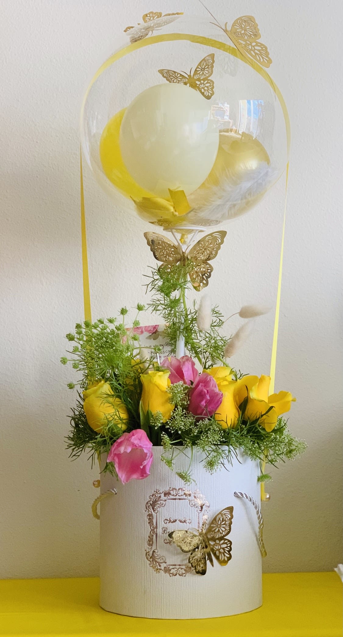 Sunny Day - Balloon flower arrangement in bright yellow colors. 12 roses, 3 hydrangeas, tulle decor inside the floral arrangement, few butterflies. There are 4 balloons of 5 inch inside the 18 inch balloon.