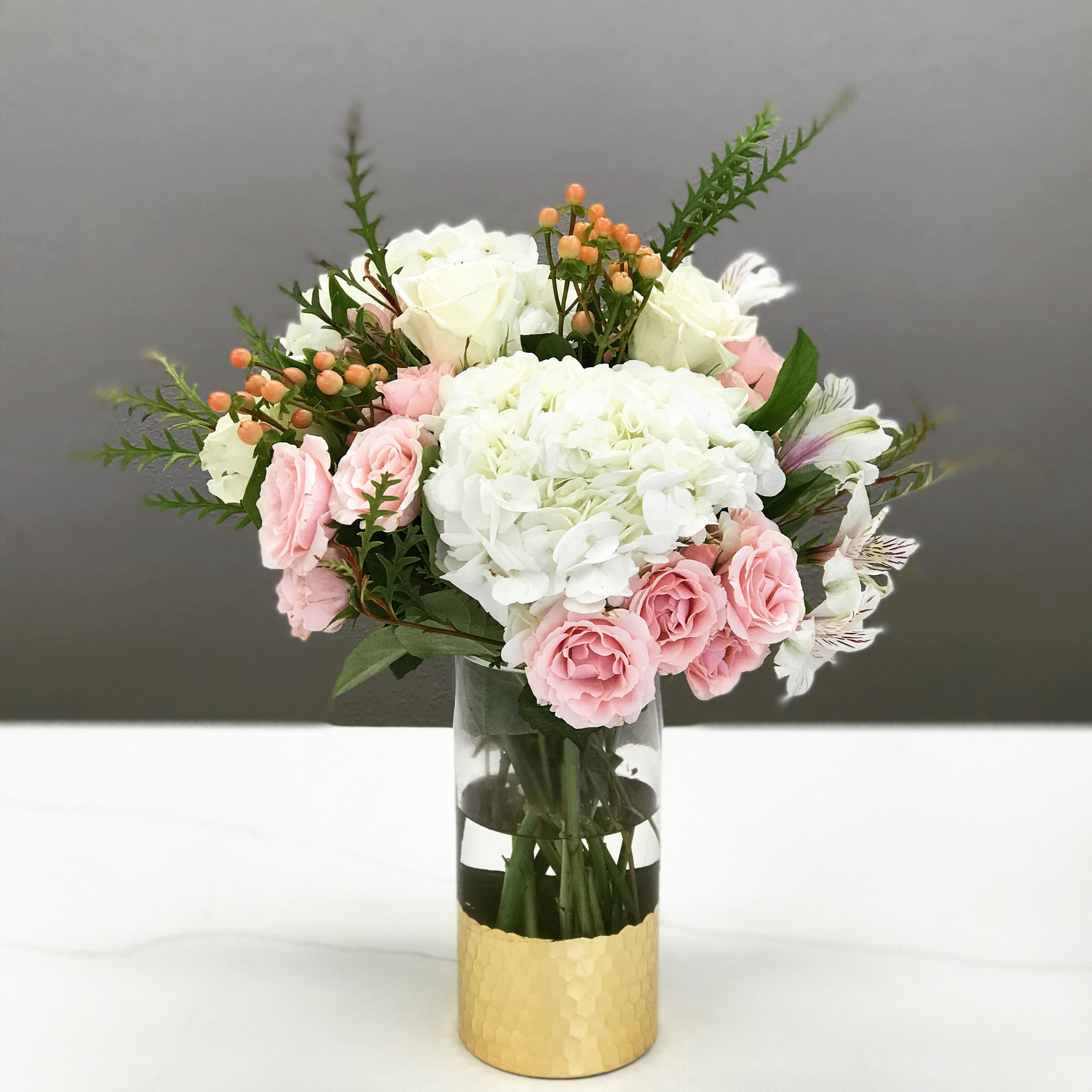 Summer Sorbet - Delicate peach and pink amongst airy white hydrangeas lend this little beauty a sassy elegance. And that gold bottom vase is just WOW!