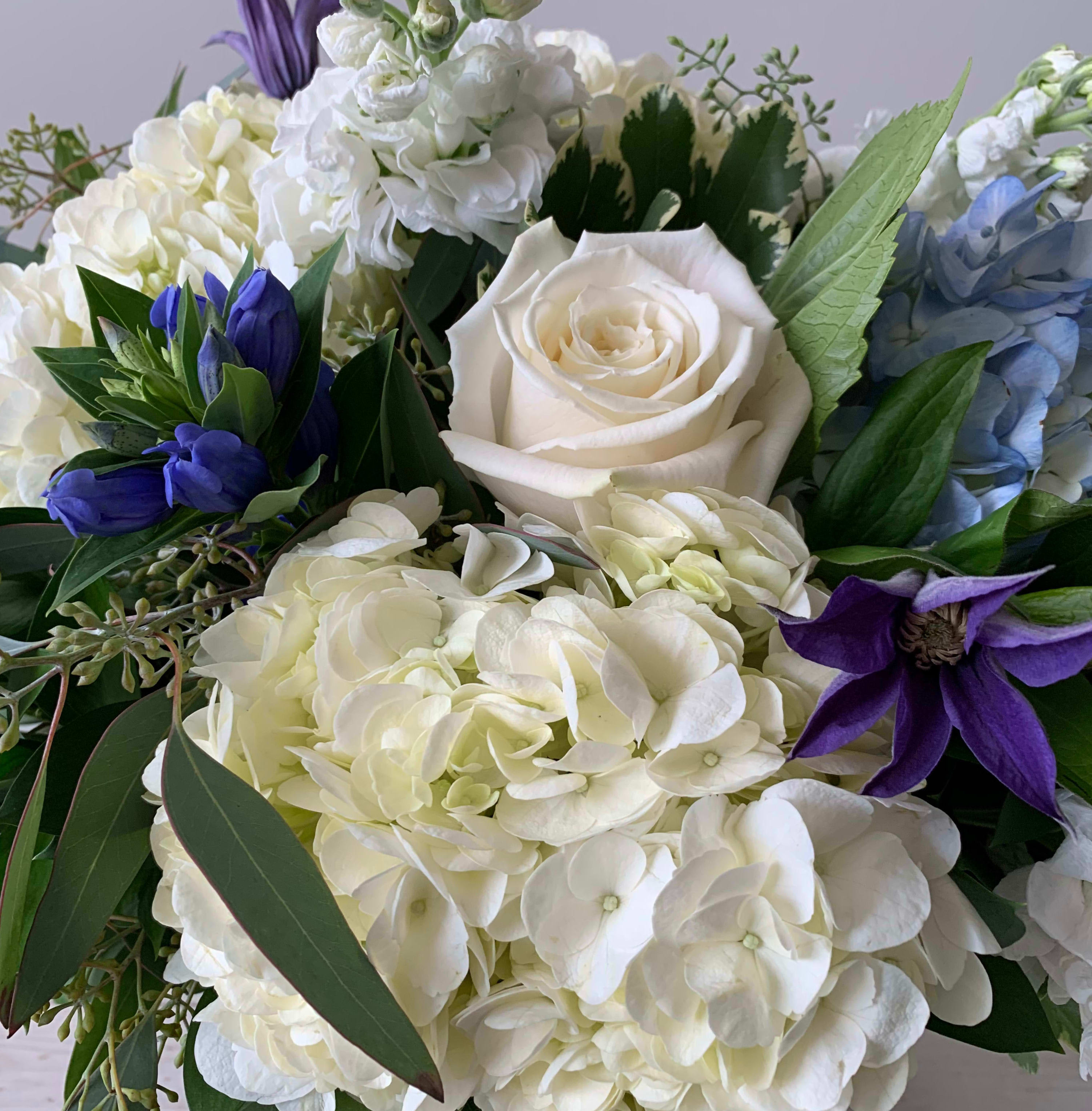 Blues and Whites - Designer's Choice - Let us do the hard work!  We'll design you a custom arrangement using a mix of the freshest blue and white blooms available.  Flowers shown in the picture are for example and not a guarantee of the type of flowers used.  