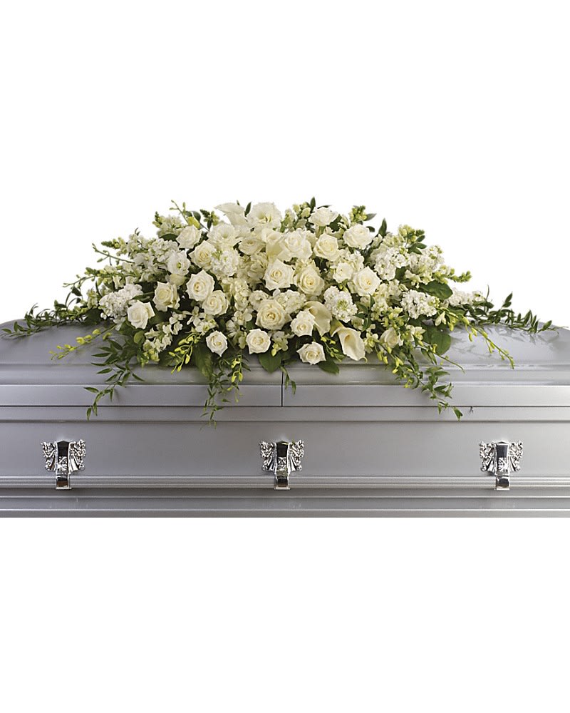 Purity and Peace Casket Spray - A stunning yet respectful testament in white, this spray for the casket includes roses, orchids, calla lilies and hydrangea accented by soft, trailing greens. White roses, orchids, large calla lilies and perfect stems of hydrangea. Approximately 47&quot; W x 17&quot; H.