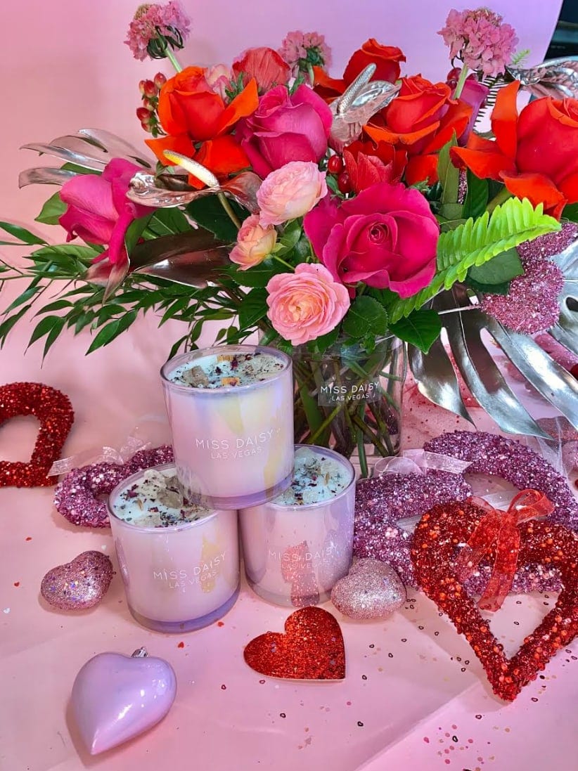 Miss Daisy Large Candle with Floral Arrangement Miss Daisy Large Candle with Floral Arrangement - Try Miss Daisy's signature Rose scented candle paired with a fabulous floral arrangement. This gift set is perfect for that special someone or even as a personal treat. Enjoy our long-lasting Rose & Crystal infused candle with a luxury Miss Daisy floral arrangement or bouquet!