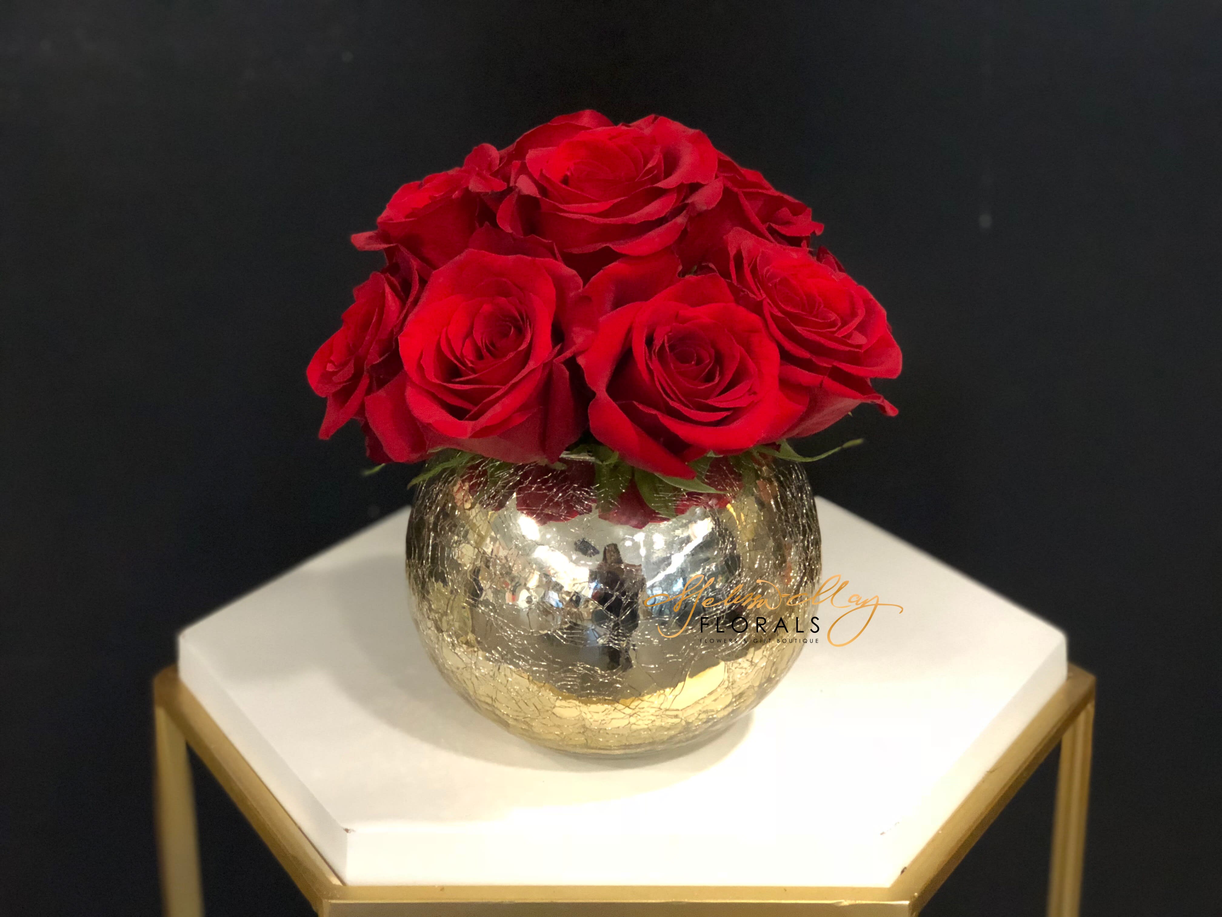 Fourteen Rosy Roses - This lovely arrangement will brighten anyone's day. These hand cut red roses are nestled in this gorgeous crackle gold vases. 