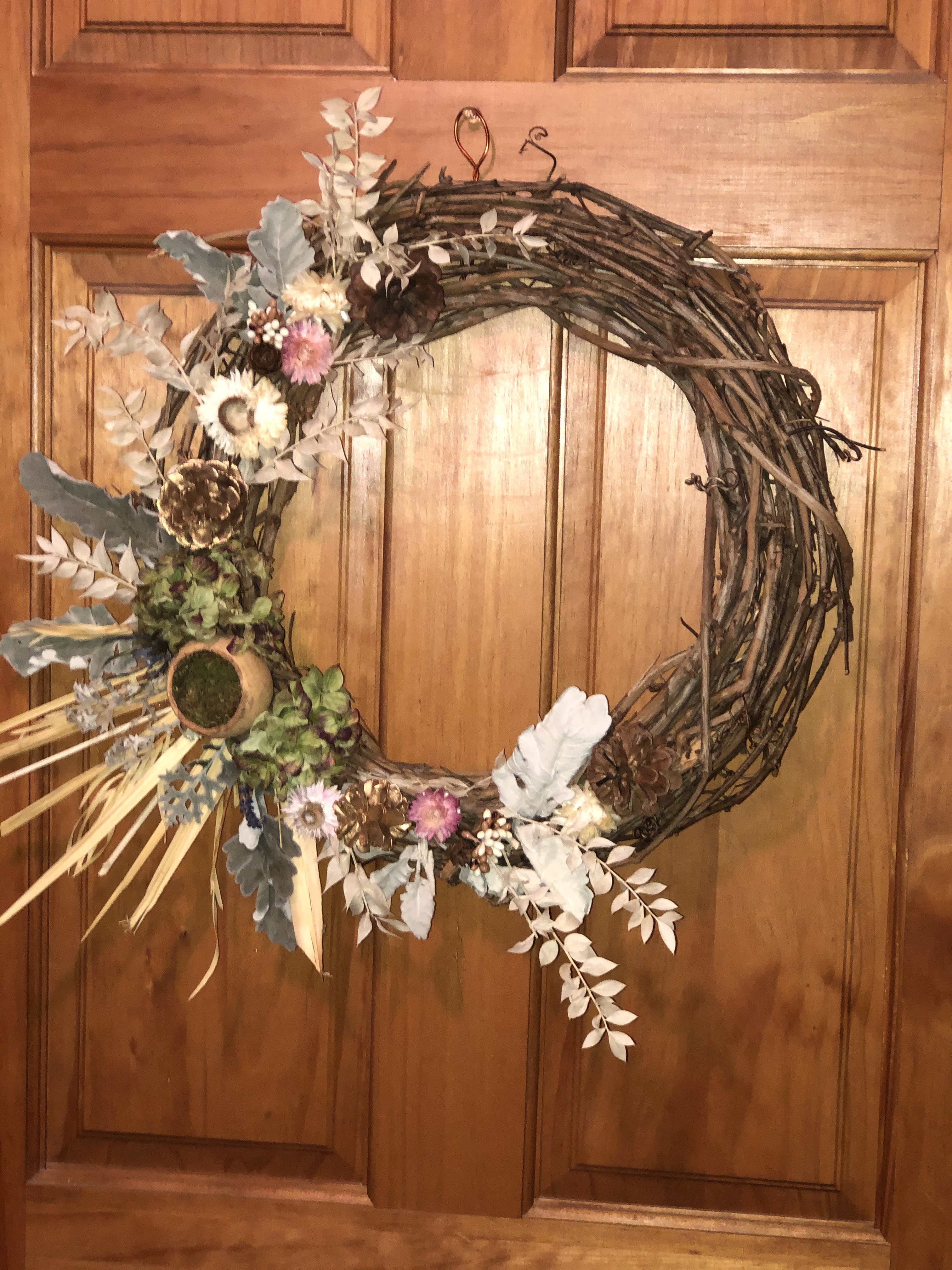 Perserved Wreath - A gorgeously preserved wreath with bleached ruscus, palm leaves, pinecones, preserved dusty miller, hydrangea, strawflowers and a preserved pod. Best for indoor use. Hanger attached. Sure to become a keepsake. Hang and store out of direct light.