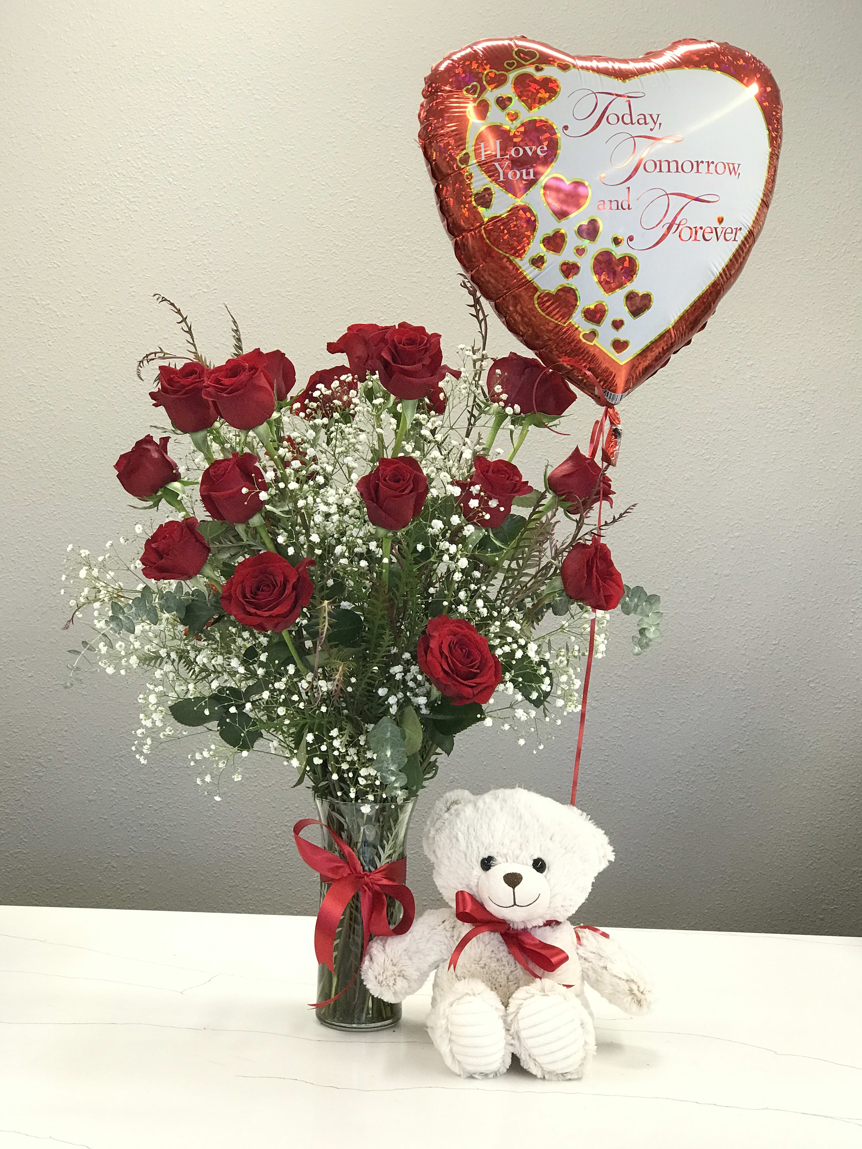 V-Day Perfection  - 2 dozen red roses sprinkled with baby's breath and tied with a dashing red ribbon are here to say I LOVE YOU. And if that wasn't enough Lil Teddy is another cuddle reminder. Celebrate your loved one with both the ephemeral and the permanent. Order The Deluxe to add a balloon!!