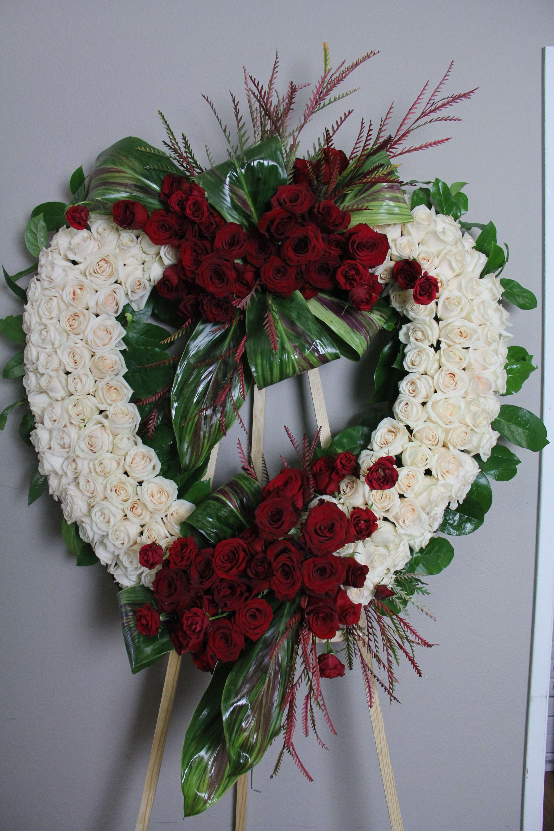 Funeral 2 Funeral 2 - Heart shaped white stand with red arrangements on both sides.