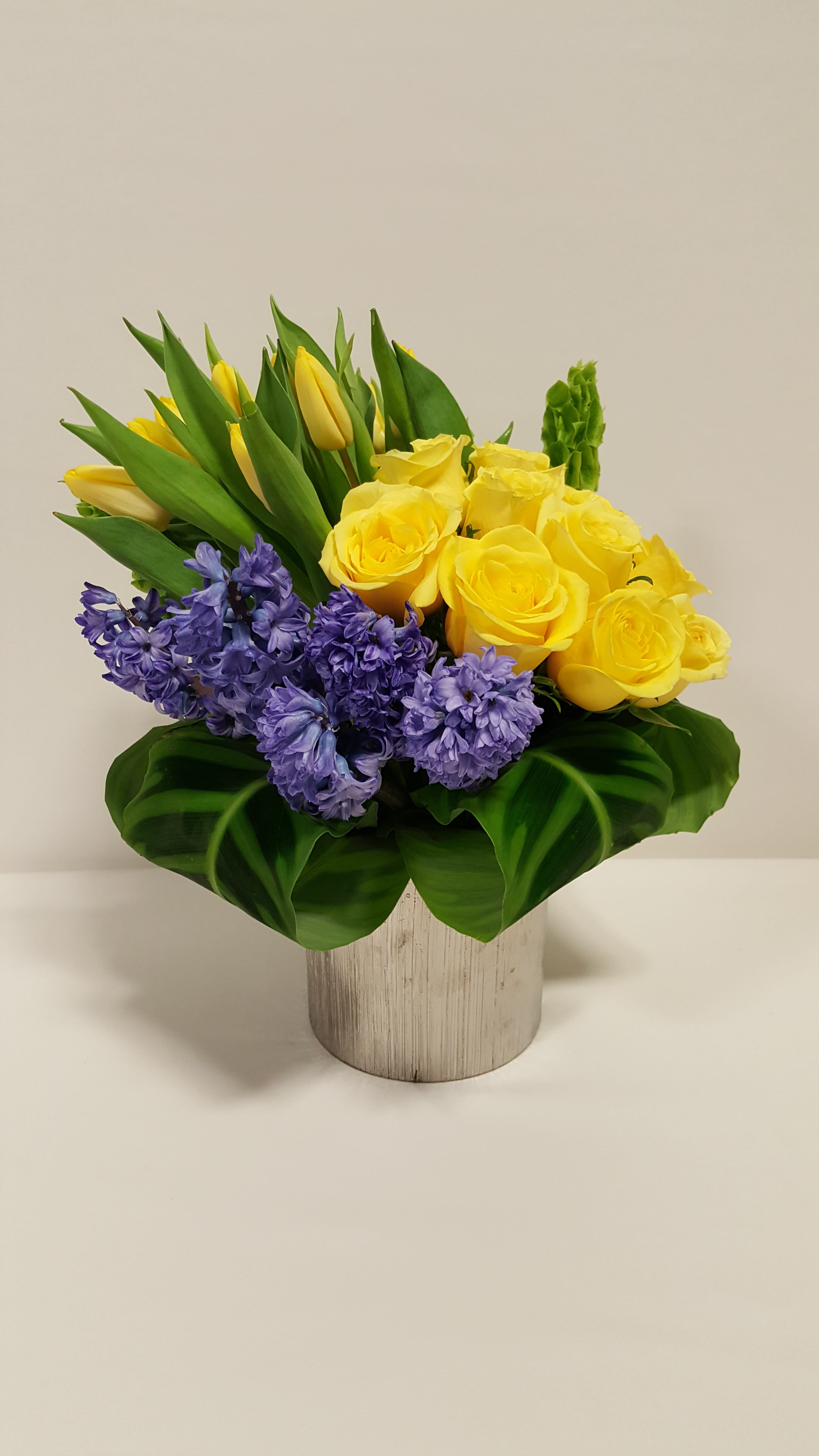 Brighten their day  -  Brighten their day with this beautiful design that comes in a ceramic cylinder vase with some lovely yellow tulips, purple hyacinth and yellow roses   Perfect for  birthday flowers anniversary flower  just because flowers  congratulations flowers  Get well flowers  Christmas flowers Valentines Day flowers Mother's Day flowers