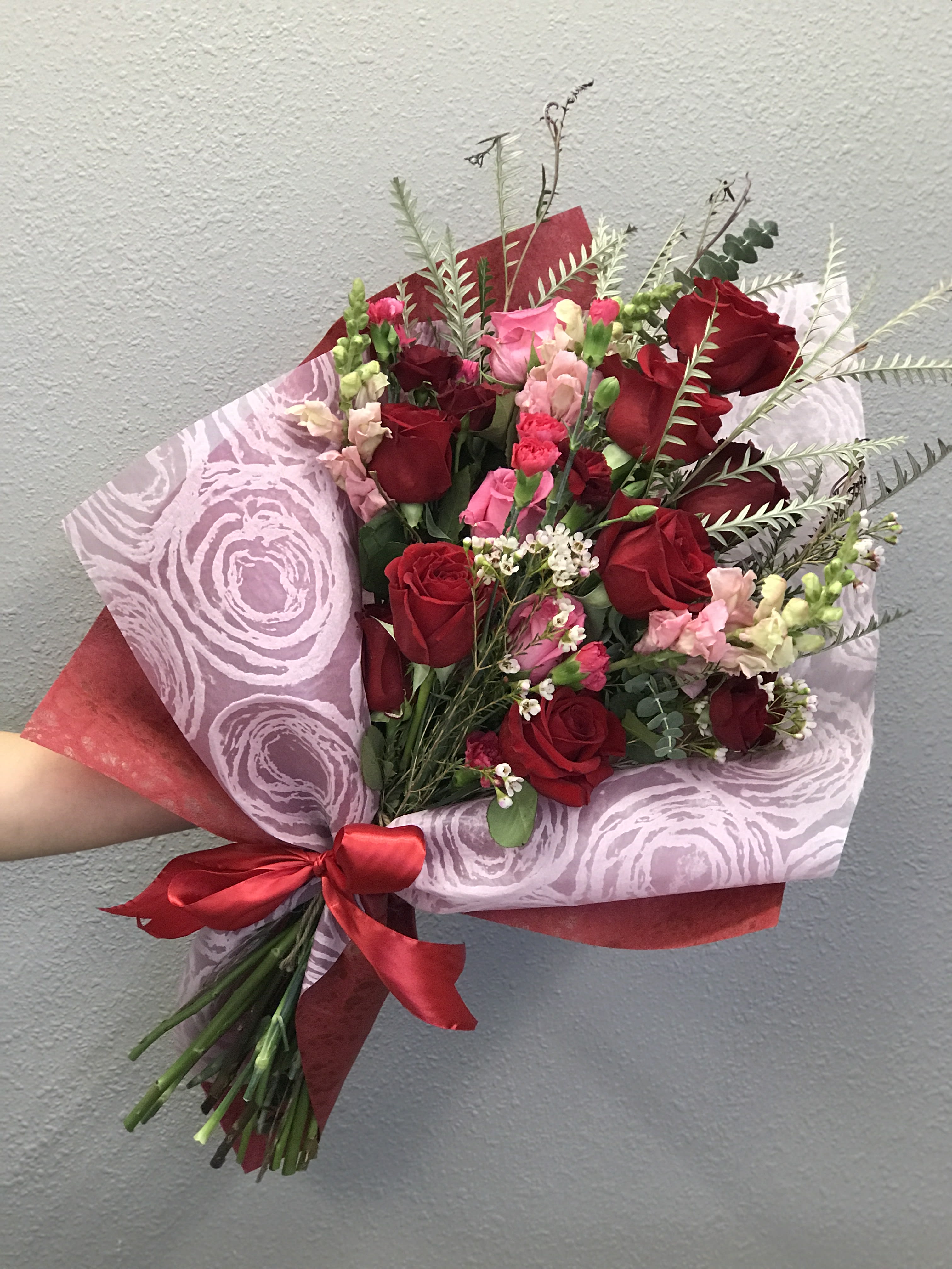 Cupid's Garden - A dozed red and pink roses with an array more red and pink blooms, hand-tied and wrapped just for your Galentine or Valentine! 